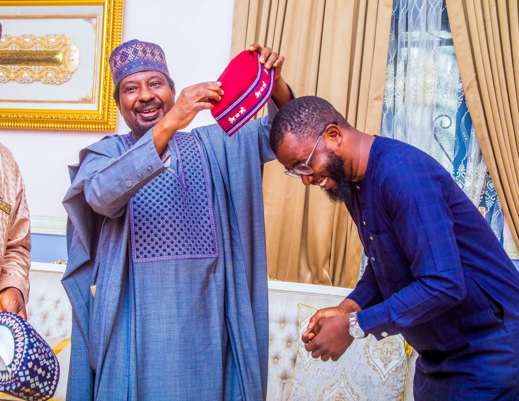 A photo of Mr Jibrin removing red cap from Ali Jita's head and the leader of the oil market